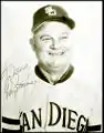 A middle-aged man wearing a light-colored San Diego baseball uniform; the photograph bears a signature saying "Don Zimmer"