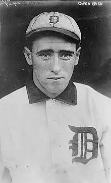 A man in a light baseball uniform and cap