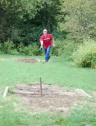 A player prepares to toss a horseshoe.