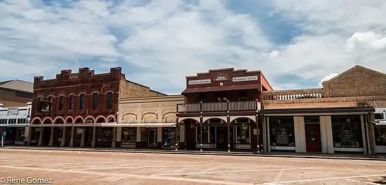 The scalloped parapet of the 1906–7 Hermes Building (left) displays the family name (2017)