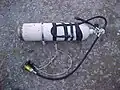 A diving cylinder ready for use on a British cave diving sidemount harness.