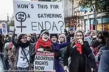 Women carrying placards saying "Abortion Rights Now"