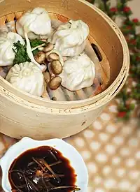 Dumplings in a basket, served with a dipping sauce