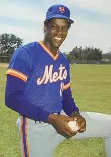 A man in a blue baseball jersey and cap and gray pants