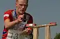 Orienteer using a SPORTIdent control card at a control point that has a needle punch for backup