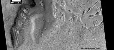 Dipping layers, as seen by HiRISE under HiWish program  Also, Ribbed Upper plains material is visible in the upper right of the picture.  It is forming from the upper plains unit, and in turn is being eroded into brain terrain.