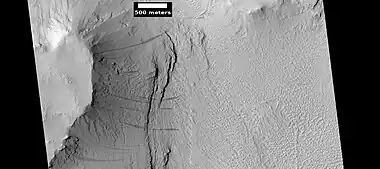 Layers under cap rock of a pedestal crater, as seen by HiRISE under HiWish program.  Pedestal crater is within the much larger Tikhonravov Crater.