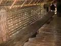 Bamboo wall and floor and a wood bench in the long house