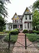 two and a half story house with large porch and irregular roof line