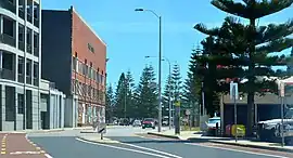 Road surrounded by buildings, with trees in the background