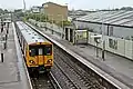 A Merseyrail Class 507 waits at the station.