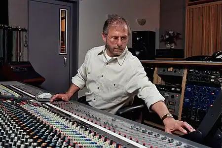 Record producer Elliot Scheiner, seated while using an audio mixing console.