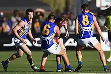 Player tackling another player during an Australian rules football game