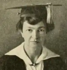 A white woman in academic robe and mortar board cap