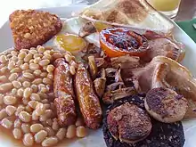 Image 31The full breakfast is among the best known British dishes, consisting of fried egg, sausage, bacon, mushrooms, baked beans, toast, fried tomatoes, and sometimes white or black pudding. (from Culture of the United Kingdom)