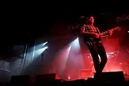 Guitarist on stage, in front of red lights