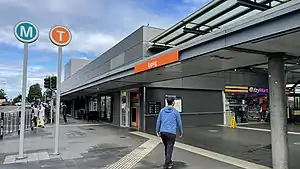 Picture of the Epping station entrance. It has two signs outside it: "M" for metro and "T" for trains.