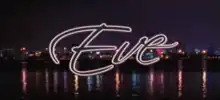 The word Eve is written in black cursive font and is presented against a nighttime panoramic image of downtown Miami.