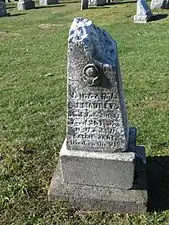 Maurey headstone shows battle damage.