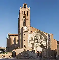 Tall, tan-colored church with a belfry