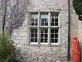 South wing with mullioned window- one pair of windows on right are blocked.