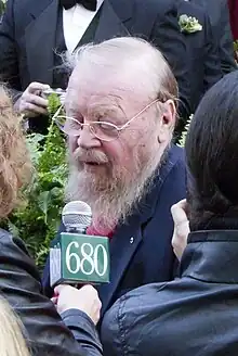 image of Mowat speaking into a microphone