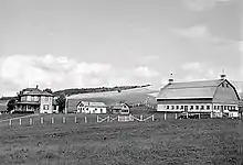 A black-and-white photo of a farm in a valley