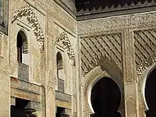 Stucco carving, including muqarnas, along the walls and arches of the courtyard