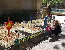 A young family look at the crosses planted in the ANZAC Field of Remembrance in Sydney, Australia