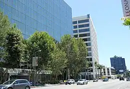 A street with modern glass-faced skyscrapers along its far side, many with logos of banks