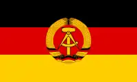 The flag of East Germany, defaced with a national emblem