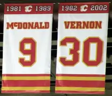 Two large white banners with red and yellow trim at the top and bottom.  They read "McDONALD 9 1981–1989" and "VERNON 30 1982–2002" respectively