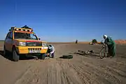 Local touaregs assisting a rally participant with a flat tyre on one of the Moroccan stages of the Budapest-Bamako