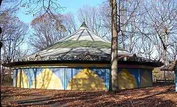 A blue and yellow pavilion surrounded by trees.