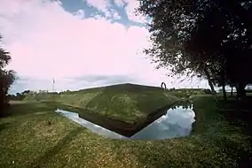 Corner of an earthen fort surrounded by a moat