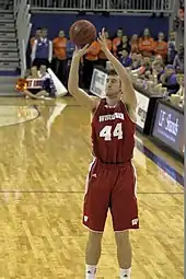 Dark-haired man shooting a basketball