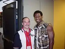 Mitchell posing with a radio station staff member backstage at a country music concert.