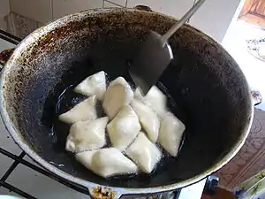 Kyrgyz boorsoq being fried in a stove-top qazan