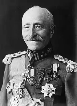 An elderly man with a prominent moustache in military uniform, adorned with medals.