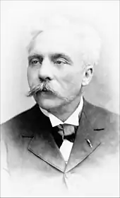 middle-aged man with full head of white hair and large white moustache