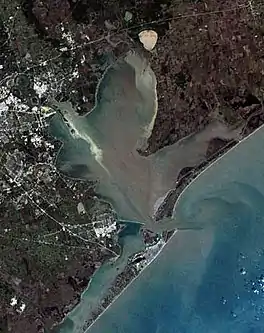 An overhead photograph of the bay showing heavy urban development on the western and southwestern edges.