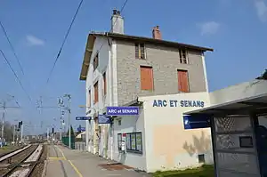 Three-story building with gabled roof next to platform