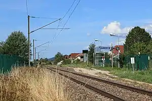 Single-track railway line next to gravel path and small shelther