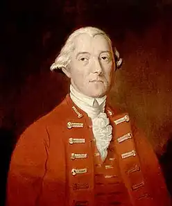 A half-height portrait of Carleton.  He wears a red coat with vest, over a white shirt with ruffles.  His white hair is drawn back, and he faces front with a neutral expression.