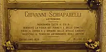 A marble gravestone on the wall of a crypt