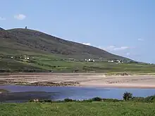 A village at the foot of a mountain, seen across a bay