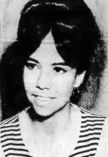 A young white woman wearing a bouffant hairstyle and a striped top.