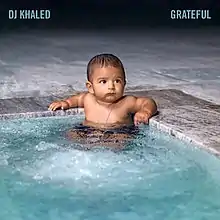 A baby sitting on a swimming pool.