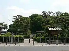 Torii gate among trees near a street.