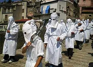 A confraternity of penitents in Italy mortifying the flesh with disciplines in a seven-hour procession; hoods similar to the capirote are worn by penitents in order to not draw attention to themselves, but to God (2010)